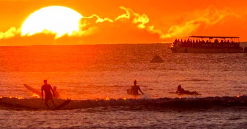 a group of people in front of a sunset